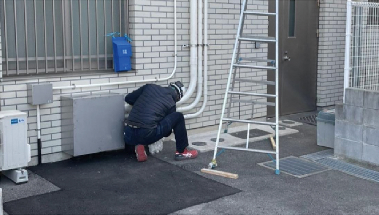 建物の外壁付近で電気設備工事を行う様子